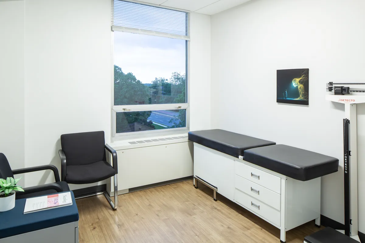 An exam room with a window view of the trees along Rockville Pike